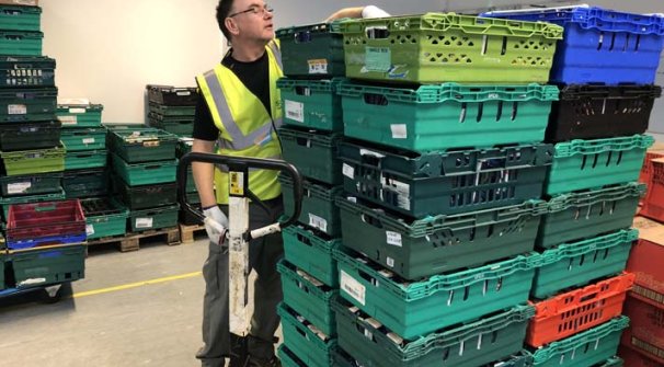 man at food bank with stacked boxes